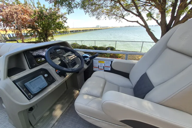 Slide: The Image of 2025 Sun Tracker Party Barge 22 RF XP3 helm with comfortable seating by a scenic lake. - 13