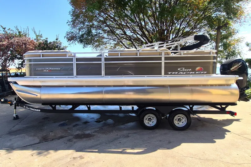 The Image of 2025 Sun Tracker Party Barge 22 RF XP3 pontoon boat on trailer, parked outdoors. - 0