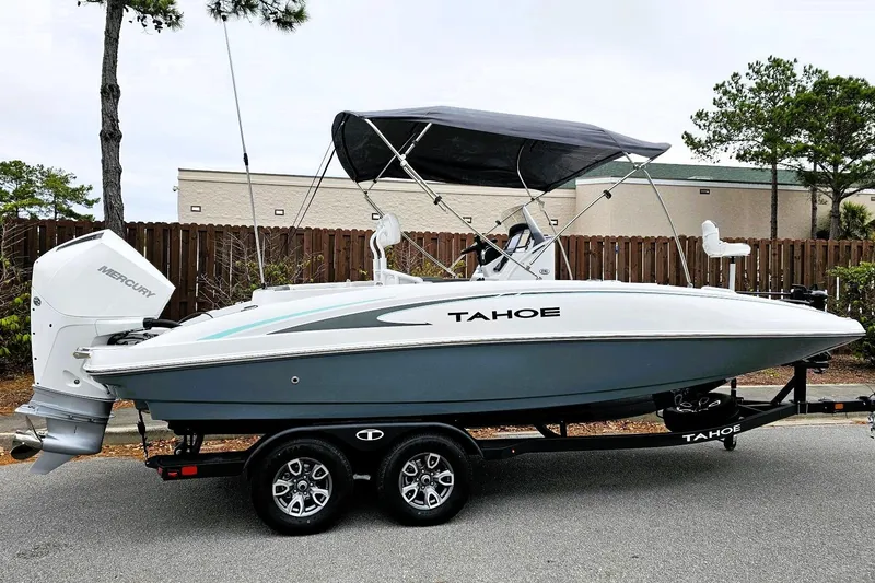 The Image of 2026 Tahoe 2150 CC boat on trailer with Mercury engine, parked outdoors. - 0