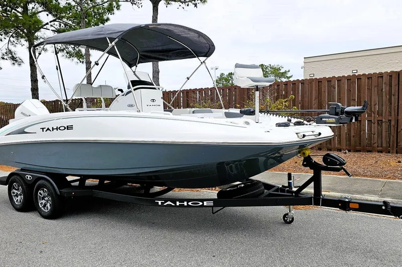 Slide: The Image of 2026 Tahoe 2150 CC boat on trailer, parked outdoors with canopy and motor. - 3