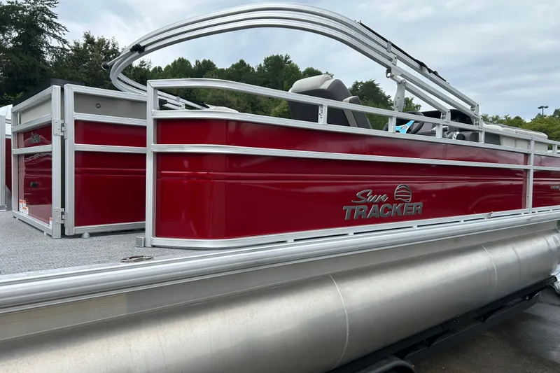 Slide: The Image of 2026 Sun Tracker Fishin' Barge 22 XP3 pontoon boat with red exterior and sleek design. - 2