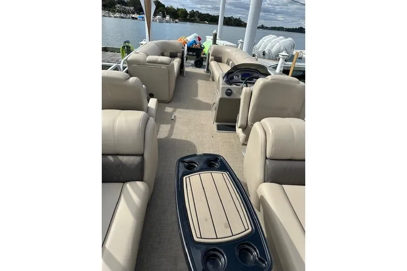 Slide: The Image of 2021 SUNTRACKER Tracker Marine boat interior at marina, featuring beige seating and life jackets. - 7