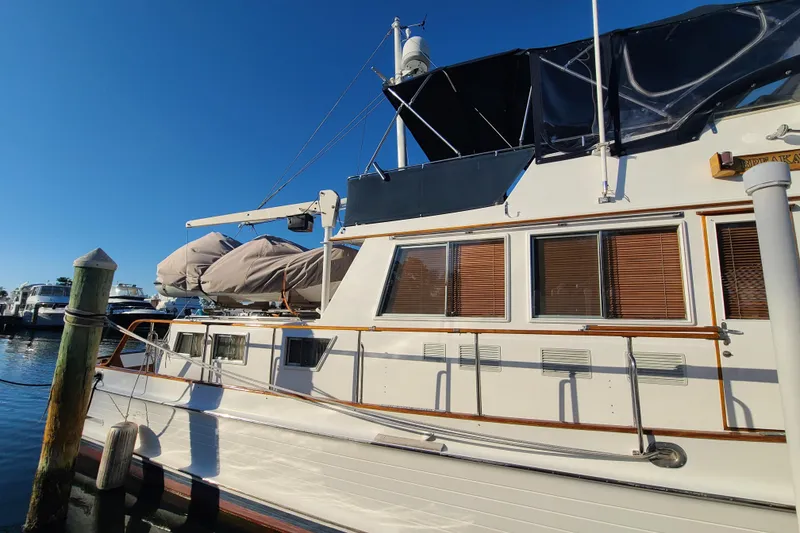 Slide: The Image of 2000 Grand Banks 46 Classic yacht docked at marina under clear blue sky. - 3