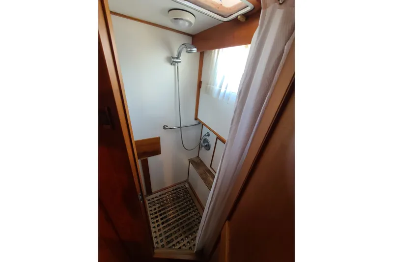 Slide: The Image of Shower area in 2000 Grand Banks 46 Classic yacht with wooden accents and curtain. - 40