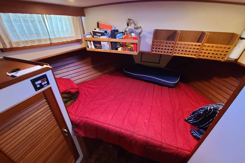 Slide: The Image of Cozy cabin interior of 2000 Grand Banks 46 Classic yacht with red bedding. - 52