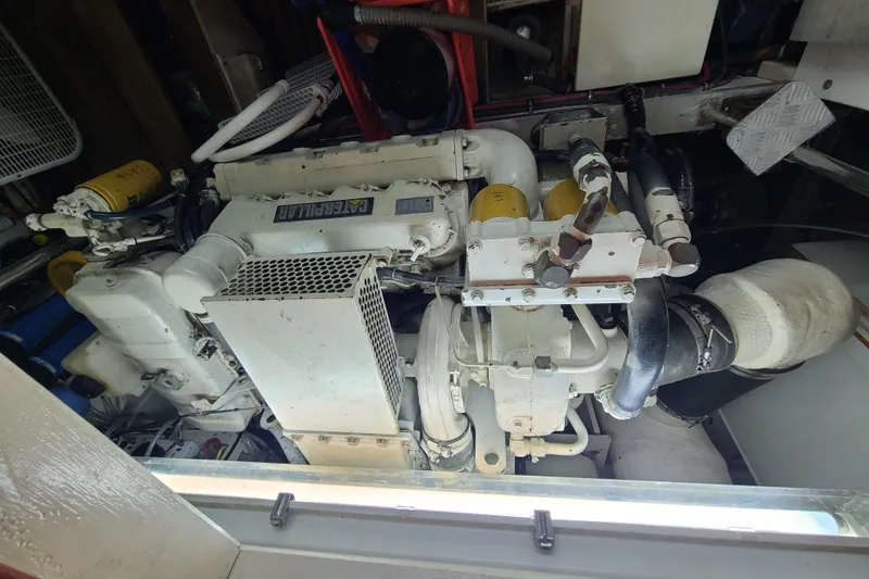Slide: The Image of Engine compartment of a 2000 Grand Banks 46 Classic yacht, featuring Caterpillar machinery. - 54
