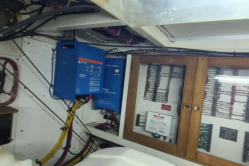 Slide: The Image of Electrical system inside a 2000 Grand Banks 46 Classic yacht, featuring wiring and control panels. - 60