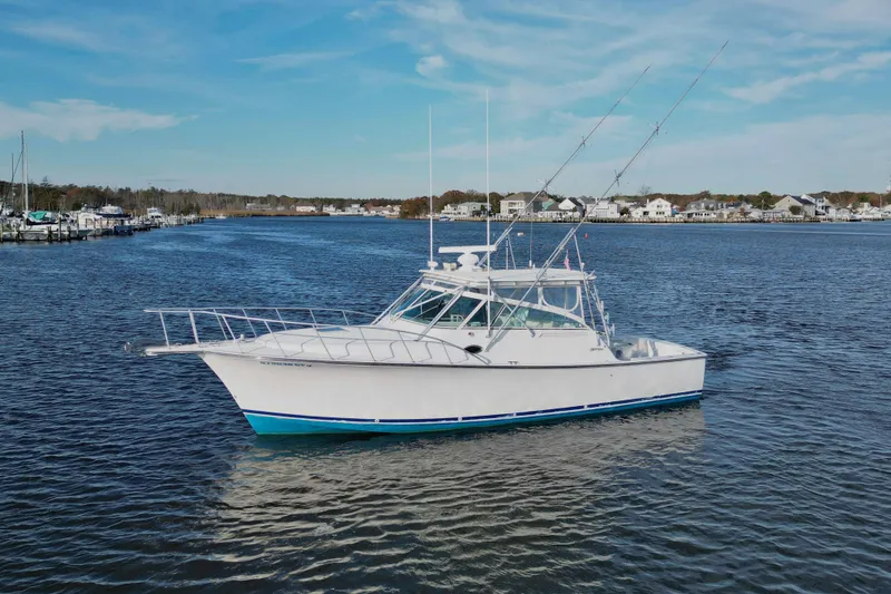 The Image of 2004 Henriques 35 Express boat on calm water with coastal houses in the background. - 1