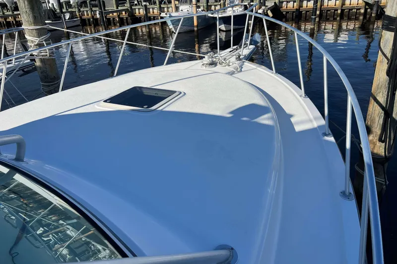 Slide: The Image of 2004 Henriques 35 Express boat deck at marina, featuring sleek design and railing. - 100