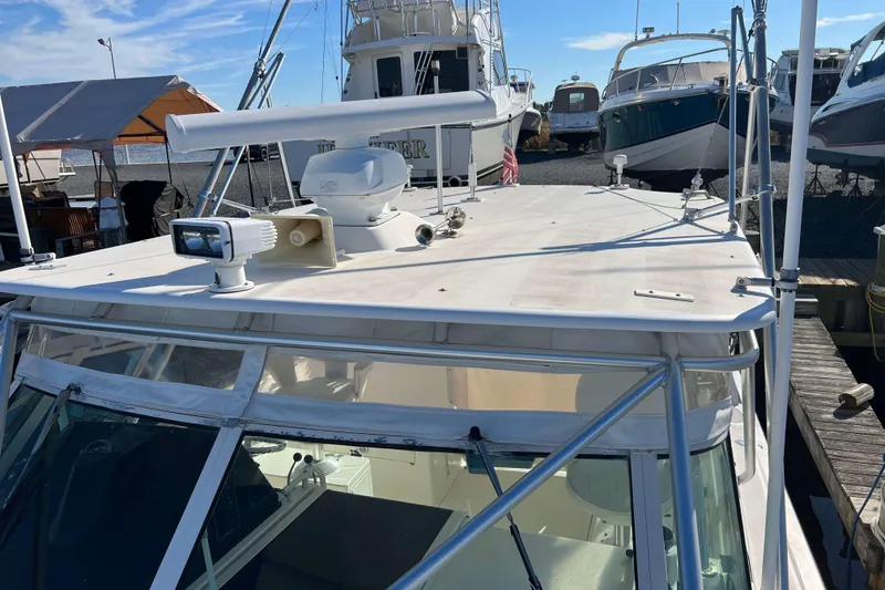 Slide: The Image of 2004 Henriques 35 Express boat docked, featuring radar and spotlight on the roof. - 103