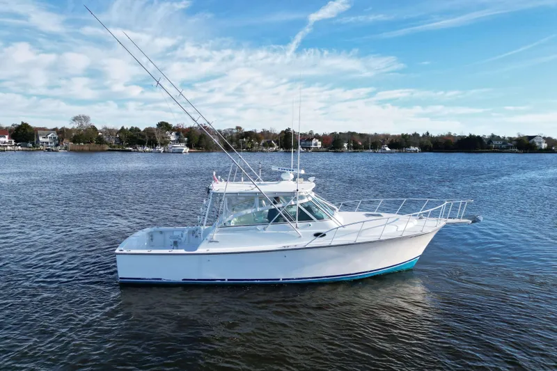 Slide: The Image of 2004 Henriques 35 Express boat on calm water under a clear blue sky. - 105