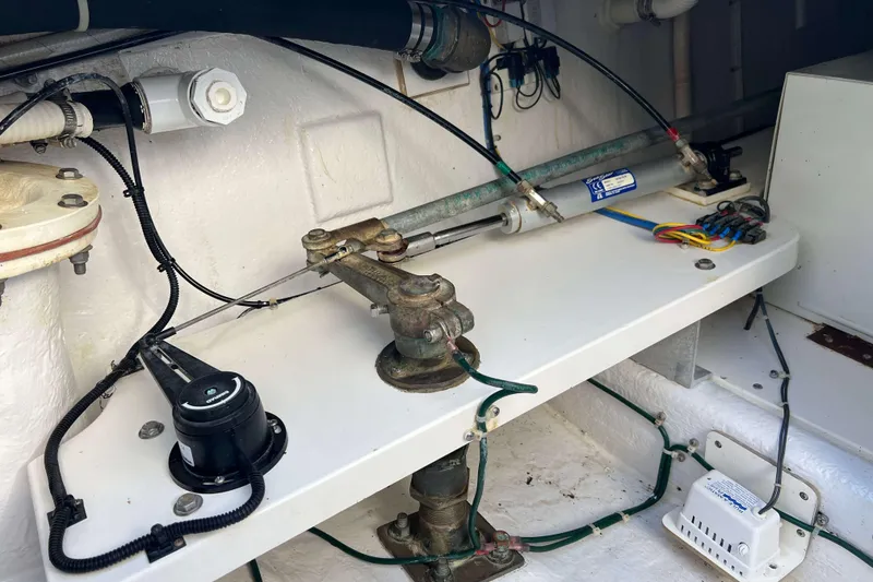 Slide: The Image of Engine compartment of a 2004 Henriques 35 Express boat, showcasing mechanical components and wiring. - 12