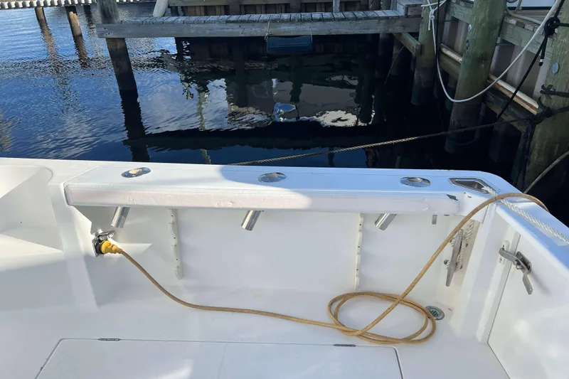 Slide: The Image of 2004 Henriques 35 Express boat deck with fishing rod holders and docked at marina. - 15