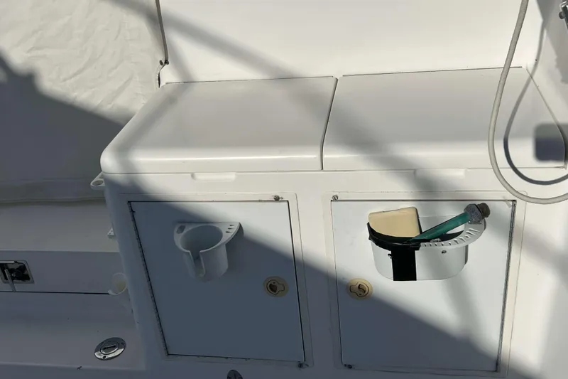 Slide: The Image of 2004 Henriques 35 Express boat interior with storage compartments and cleaning tools. - 24