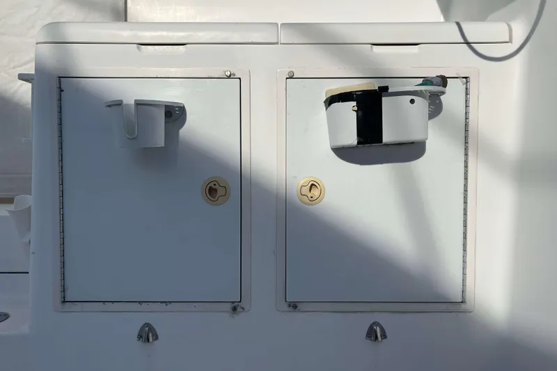 Slide: The Image of 2004 Henriques 35 Express boat storage compartments with latches and mounted equipment. - 27