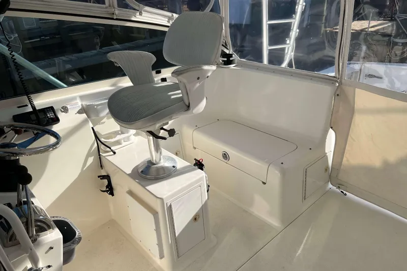Slide: The Image of 2004 Henriques 35 Express boat interior with helm seat and storage bench. - 36