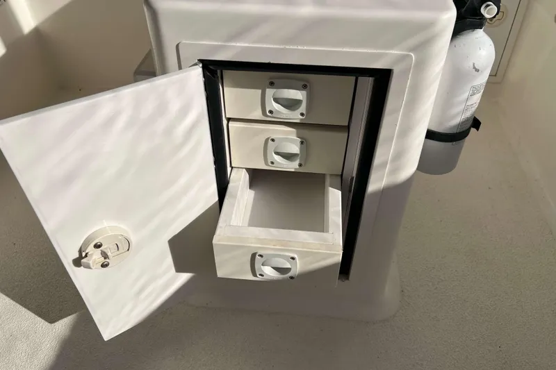 Slide: The Image of Open storage compartment on 2004 Henriques 35 Express boat with drawers and fire extinguisher. - 42