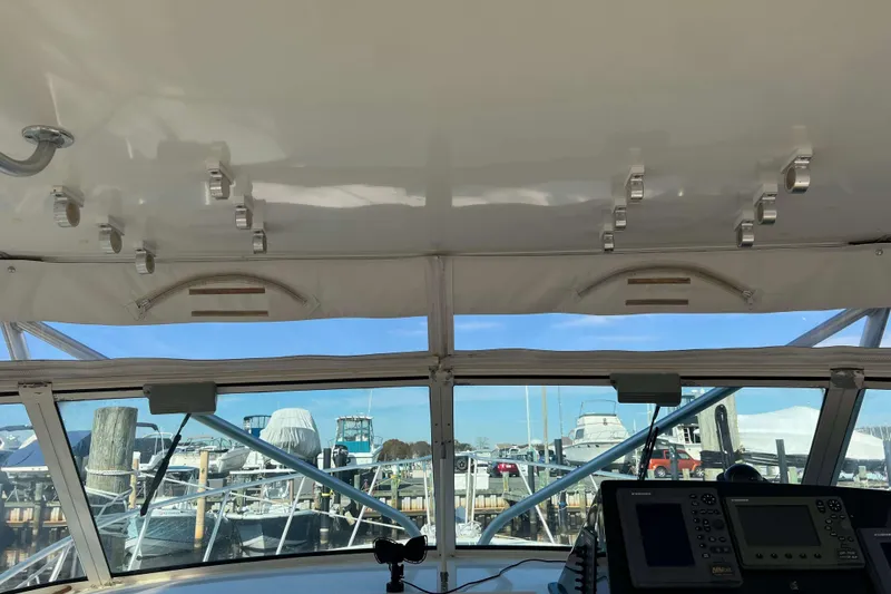 Slide: The Image of Interior view of a 2004 Henriques 35 Express boat, showcasing the helm and marina. - 45