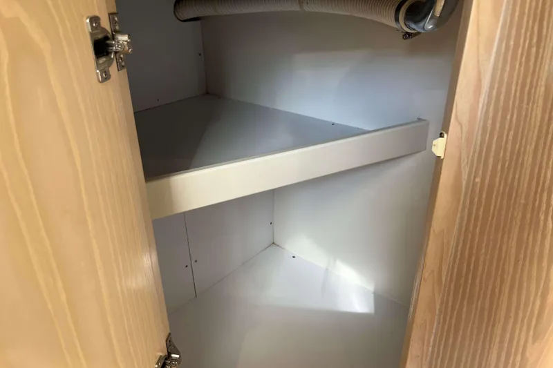 Slide: The Image of Open wooden cabinet with white interior shelves and visible hose, Henriques 35 Express 2004. - 52