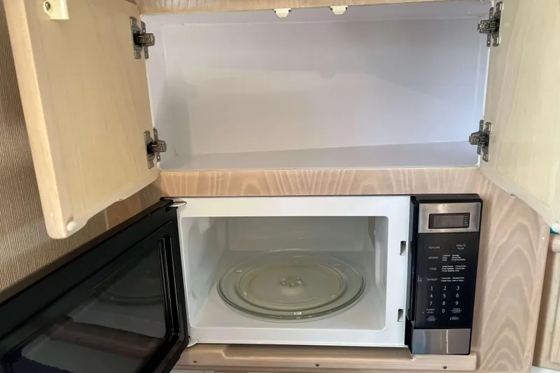 Slide: The Image of Microwave and open cabinet inside 2004 Henriques 35 Express boat kitchen. - 53