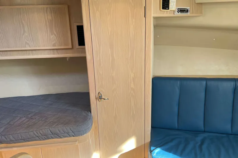 Slide: The Image of Interior of 2004 Henriques 35 Express boat with wooden cabinetry and blue seating. - 56