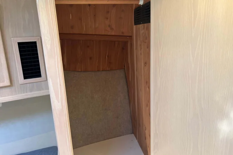 Slide: The Image of Interior of 2004 Henriques 35 Express boat with wooden paneling and storage space. - 57