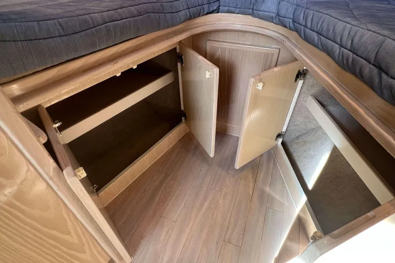 Slide: The Image of 2004 Henriques 35 Express cabin storage with open wooden cabinets and blue bedding. - 64