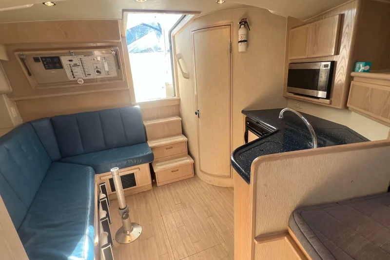 Slide: The Image of 2004 Henriques 35 Express interior with blue seating, kitchenette, and control panel. - 65