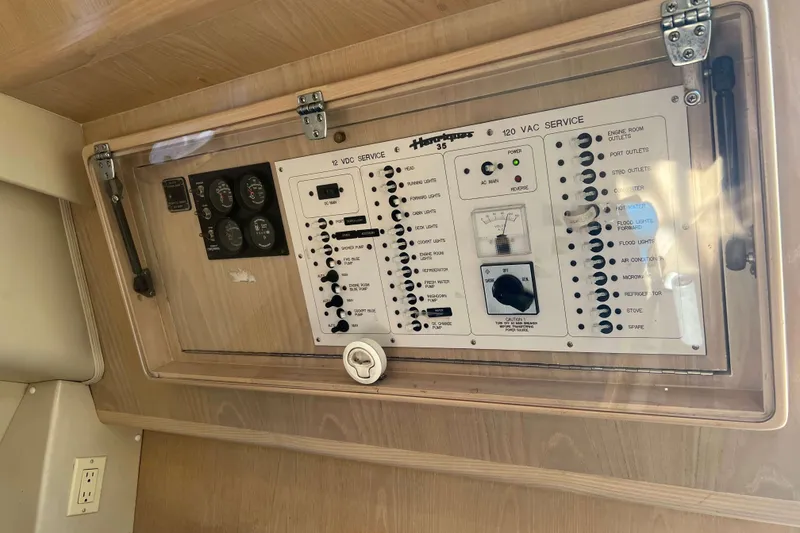 Slide: The Image of Electrical panel of a 2004 Henriques 35 Express boat, featuring various switches and gauges. - 70