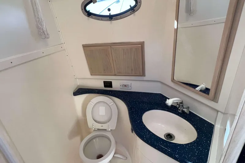 Slide: The Image of 2004 Henriques 35 Express boat bathroom with sink, toilet, and mirror. - 72