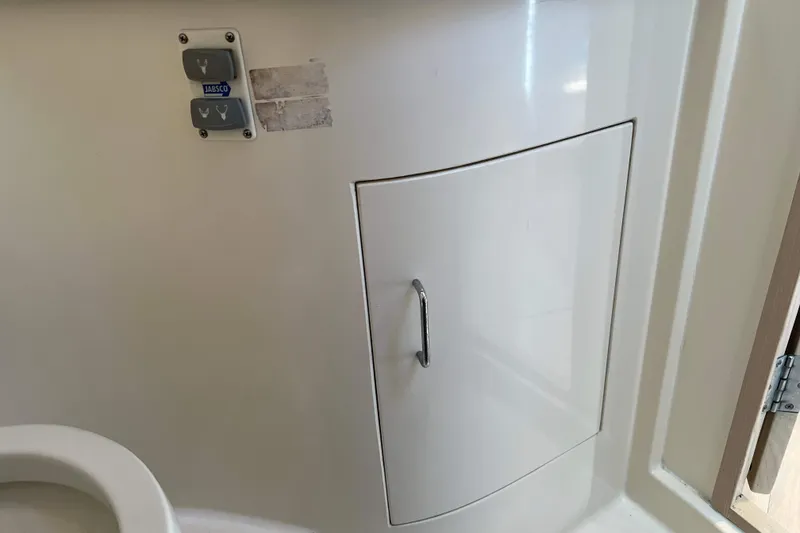 Slide: The Image of 2004 Henriques 35 Express boat interior with Jabsco control panel and storage compartment. - 76