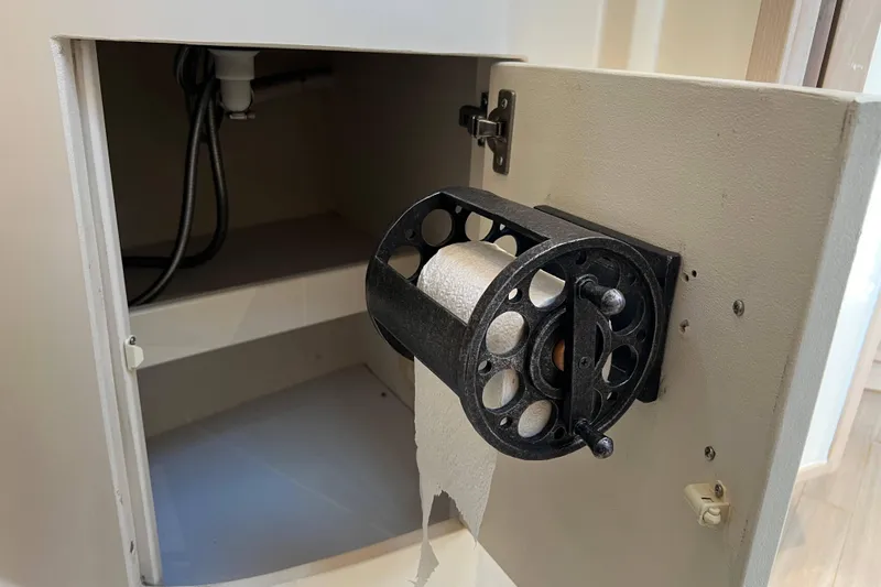 Slide: The Image of Unique toilet paper holder inside a cabinet on a 2004 Henriques 35 Express boat. - 77