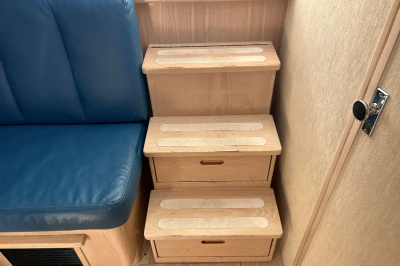 Slide: The Image of Wooden steps with storage on a 2004 Henriques 35 Express boat interior. - 80
