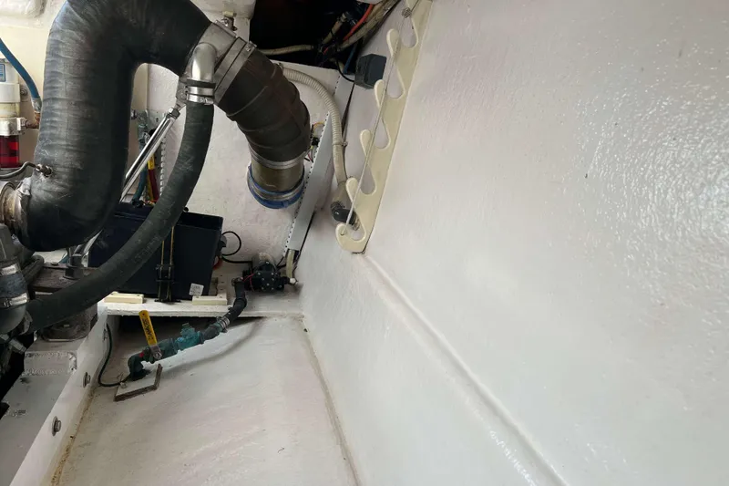 Slide: The Image of Engine room of 2004 Henriques 35 Express boat with visible hoses and components. - 93