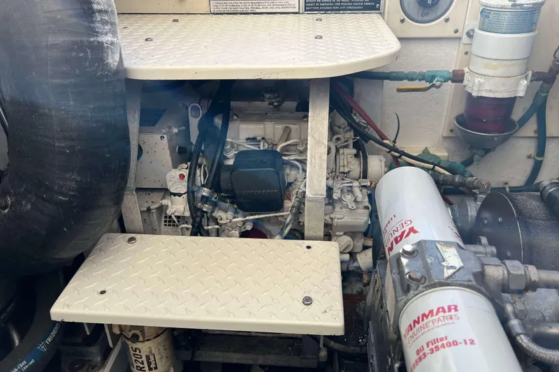 Slide: The Image of Engine compartment of a 2004 Henriques 35 Express boat, featuring Yanmar components. - 98