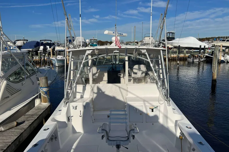 Slide: The Image of 2004 Henriques 35 Express boat docked at marina under clear blue sky. - 99