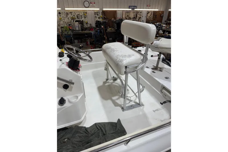 Slide: The Image of 2004 NauticStar 2200 NauticBay boat interior with steering wheel and seating in a workshop. - 5