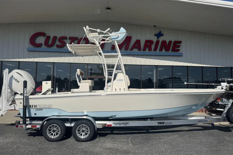 The Image of 2026 Pathfinder 2500 Hybrid boat on trailer at Custom Marine dealership. - 1