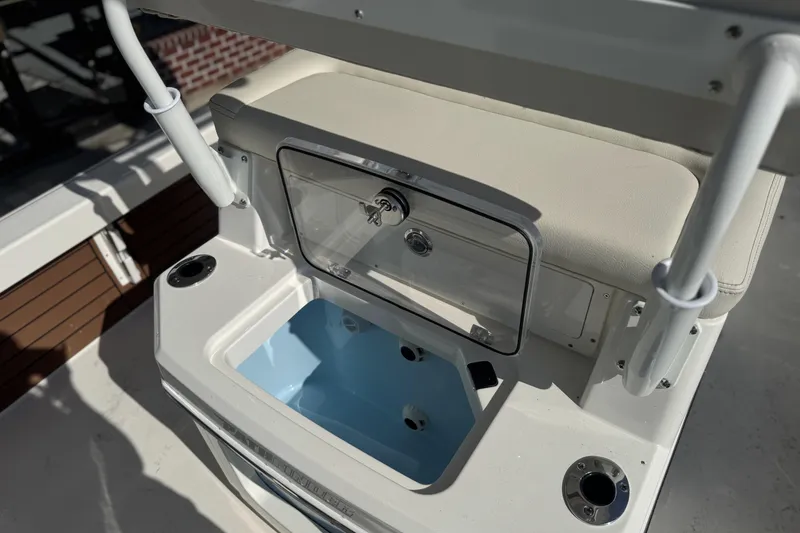Slide: The Image of 2026 Pathfinder 2500 Hybrid boat with open storage compartment and cup holders. - 19