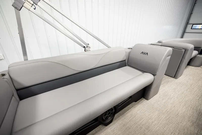 Slide: The Image of 2026 Avalon VLS QL boat interior with gray seating and cup holders in a showroom. - 20