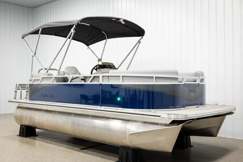 Slide: The Image of 2026 Avalon VLS QL pontoon boat in showroom, featuring sleek blue design and canopy. - 3