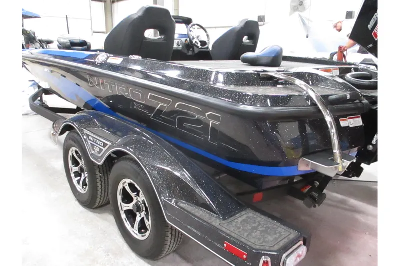Slide: The Image of 2025 Nitro Z21 XL boat with sleek design and dual-axle trailer in a showroom. - 0