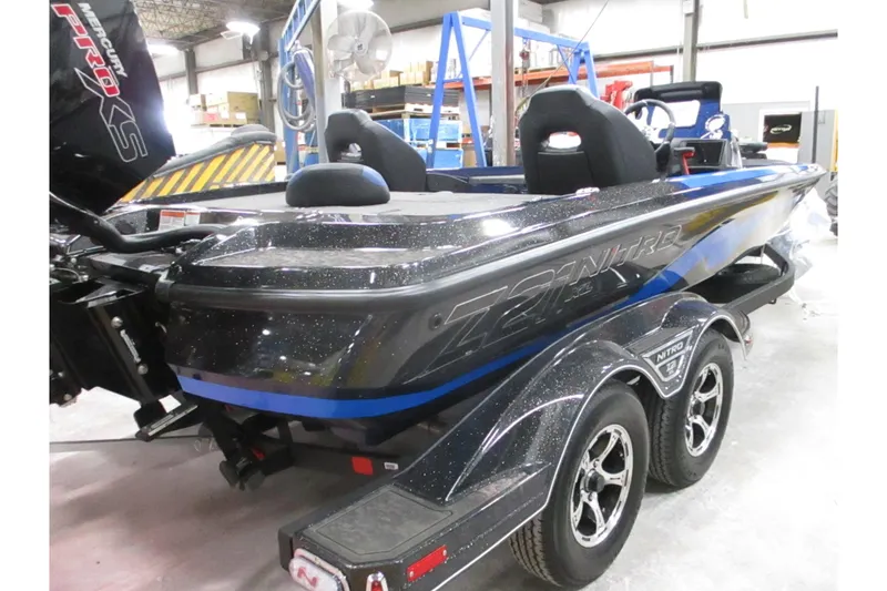 Slide: The Image of 2025 Nitro Z21 XL boat in showroom, featuring sleek design and dual-axle trailer. - 1
