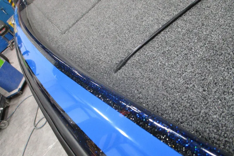 Slide: The Image of 2025 Nitro Z21 XL boat interior with blue trim and carpeted flooring. - 10