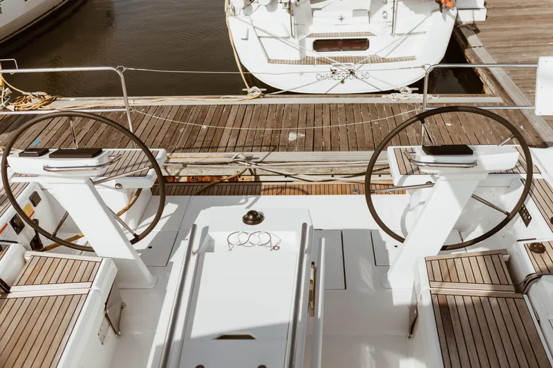 Slide: The Image of 2024 Beneteau Oceanis 51.1 yacht cockpit with dual steering wheels at dock. - 5