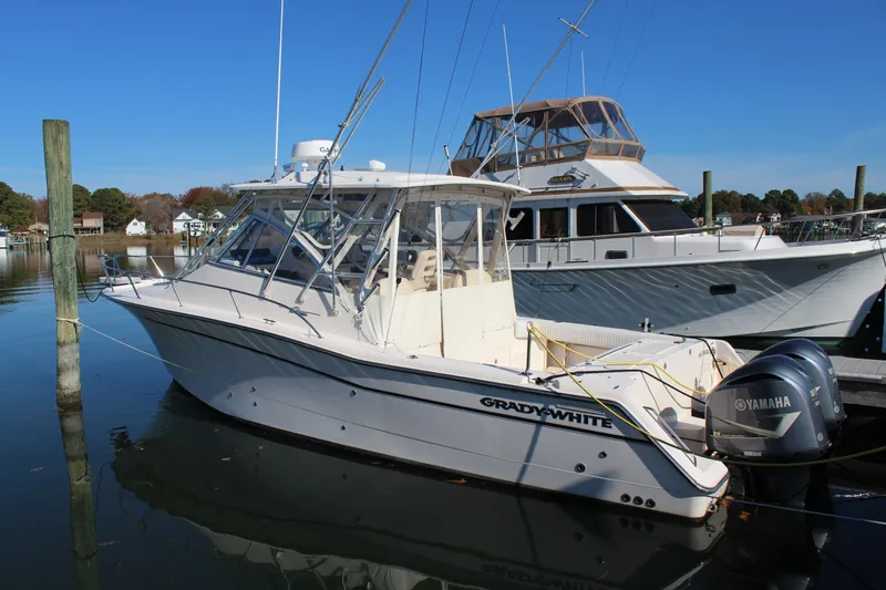 The Image of 2008 Grady-White Express 330 boat cruising on a calm lake with forested shoreline. - 0