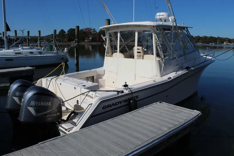 Slide: The Image of 2008 Grady-White Express 330 boat on calm water, surrounded by trees and houses. - 1