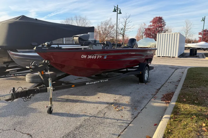 Slide: The Image of 2016 Ranger VS1680 boat on trailer in parking lot, autumn trees in background. - 2