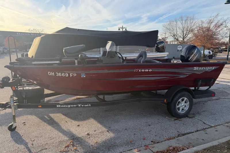 Slide: The Image of 2016 Ranger VS1680 boat on trailer in parking lot, red exterior, Mercury engine. - 3