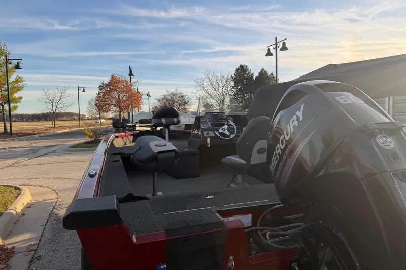 Slide: The Image of 2016 Ranger VS1680 boat with Mercury engine, parked near a scenic autumn landscape. - 6